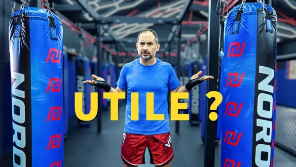 Greg, coach de Boxe, hésite entre un sac de frappe et un partenaire dans la salle NOROS
